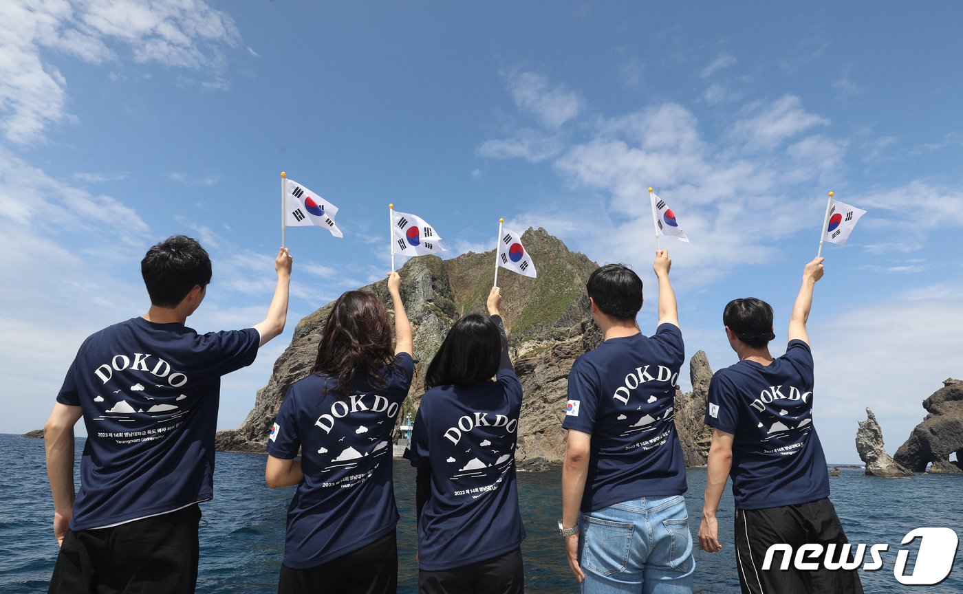 본문 이미지 - '2023학년도 영남대학교 독도 역사 바로 알기'에 참여한 학생들이 지난 19일 오전 독도를 찾아 동도(東島) 선착장에서 독도 입도를 축하하는 퍼포먼스를 90초 이내의 짧은 영상에 담는 숏폼 콘텐츠로 제작하고 있다. 2023.8.19/뉴스1 ⓒ News1 공정식 기자