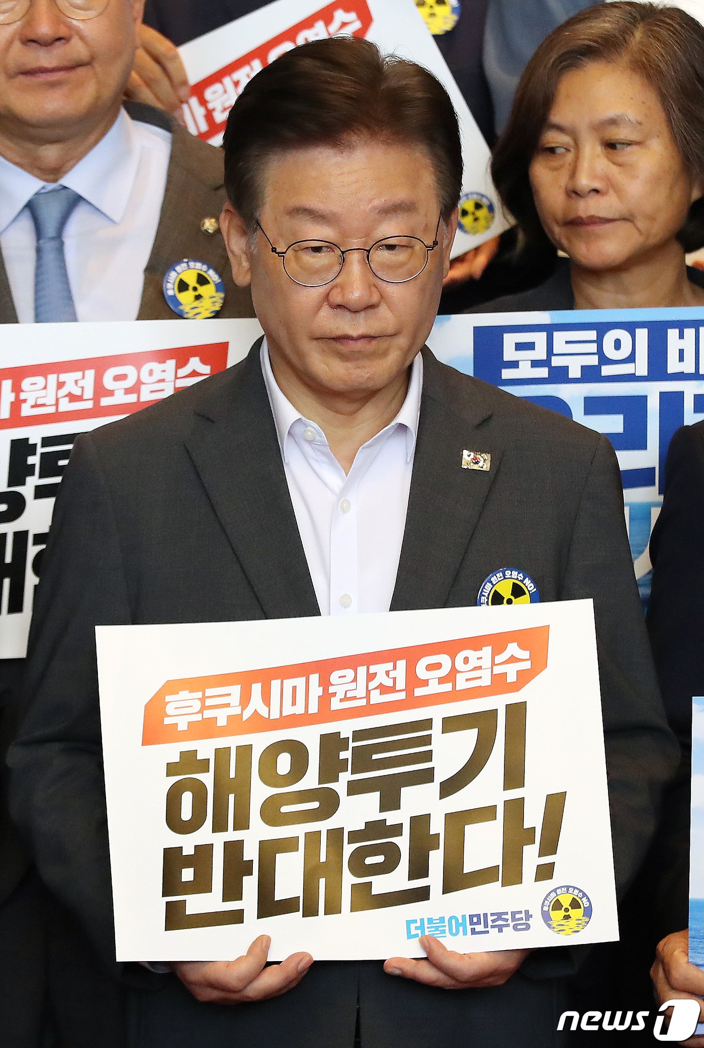 본문 이미지 - 이재명 더불어민주당 대표가 22일 오후 서울 여의도 국회 로텐더홀에서 열린 긴급 의원총회 및 일본 후쿠시마 원전오염수 해양방류 규탄대회에서 피켓을 들고 있다. 2023.8.22/뉴스1 ⓒ News1 임세영 기자