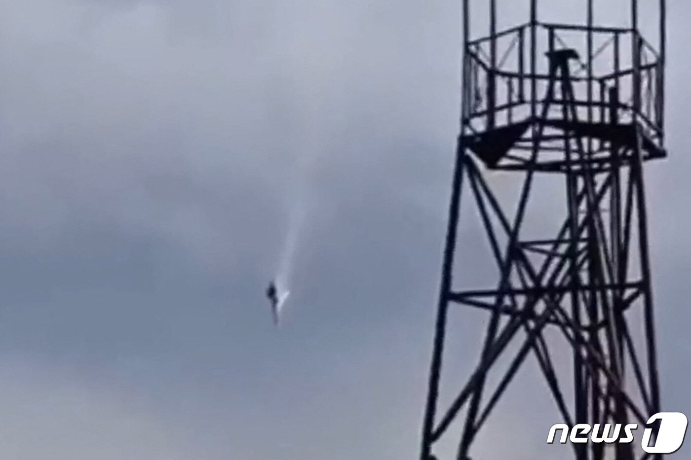 본문 이미지 - 철제 구조물 뒤로 추락하고 있는 비행기. 2023.8.24 ⓒ AFP=뉴스1 ⓒ News1 우동명 기자