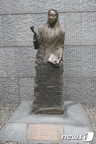 본문 이미지 - 아이리스 장 동상, 자신의 책을 들고 있다. - 위키피디아 갈무리