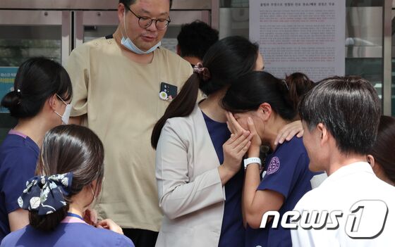 서울백병원 진료 마지막 날인 31일 오후 서울 중구 인제대학교 서울백병원 입구에서 의료진 등 교직원들이 폐원 전 마지막 기념촬영을 마친 뒤 슬픔을 나누고 있다. 2023.8.31/뉴스1 © News1 장수영 기자