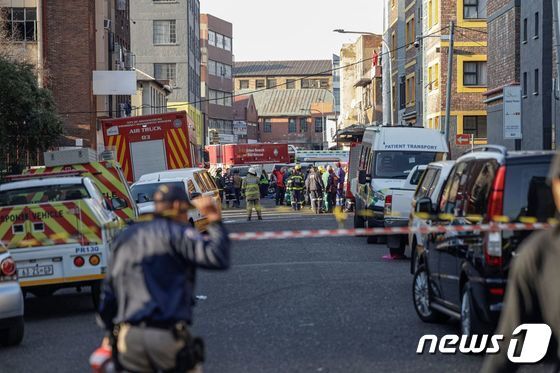 31일 화재가 발생한 남아공 요하네스버그 현장에서 경찰들이 교통을 통제하고 있다. © AFP=뉴스1 © News1 박형기 기자