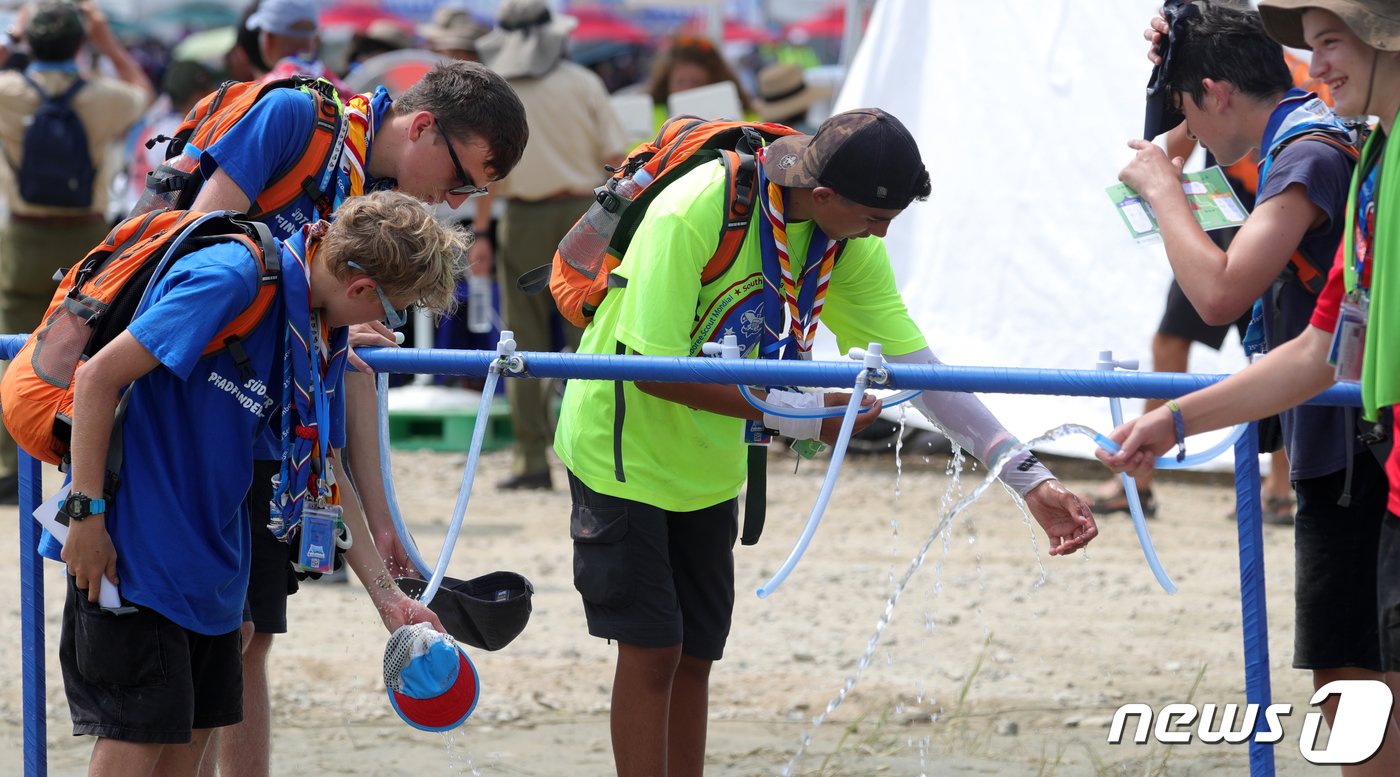 본문 이미지 - 4일 전북 부안군 세계스카우트잼버리 텔타구역에서 스카우트 대원들이 수돗가에서 물을 뿌리며 더위를 식히고 있다. 한편 잼버리 조직위원회는 새만금 세계스카우트 잼버리 야영장에서 온열질환자가 속출하자 폭염 대비 냉수 공급 확대와 쿨링버스 130대 배치 등 관련 대책을 내놨다.2023.8.4/뉴스1 ⓒ News1 유경석 기자