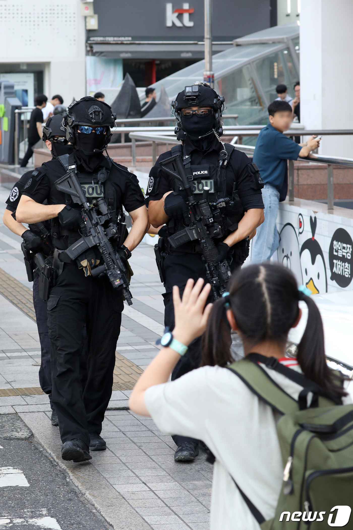 (대구=뉴스1) 공정식 기자 = 6일 오후 흉기 난동 등 범죄 예방을 위해 대구 중구 동성로~중앙로 구간에 배치된 경찰특공대가 순찰을 강화한 가운데 한 어린이가 경찰관을 향해 손을 …