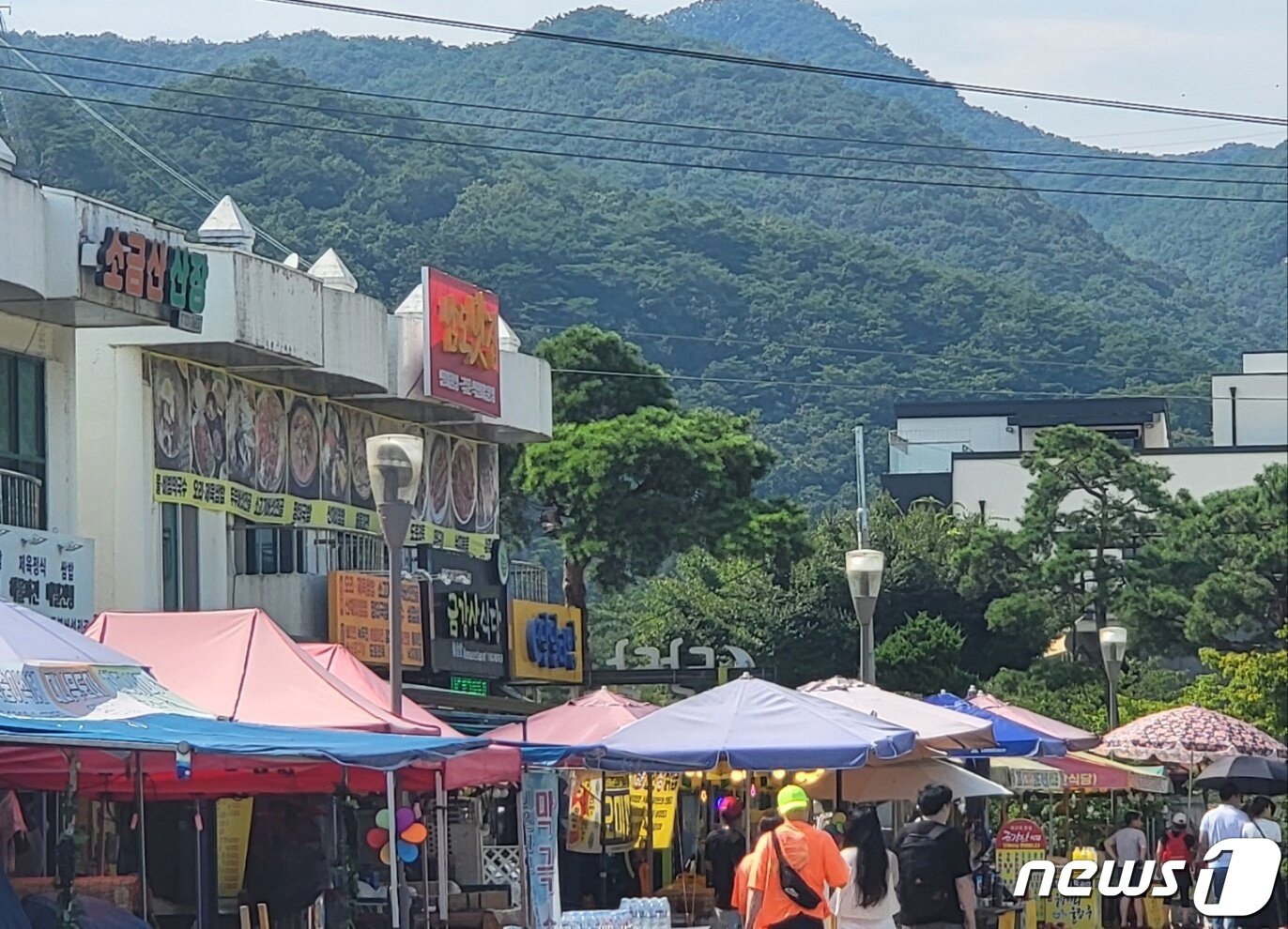 본문 이미지 - 6일 강원 원주시 간현관광지에 800명이 넘는 여행객이 방문한 가운데, 일부 여행객이 관광지 입구 주변 상가를 지나가고 있다. 2023.8.6/뉴스1 신관호 기자