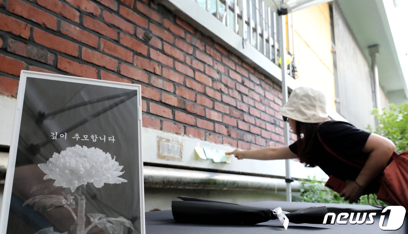 본문 이미지 - 7일 오후 서울 서초구 서이초등학교 1학년 6반 교실 외벽에 설치된 추모공간을 찾은 시민이 고인이 된 교사를 추모하고 있다. 2023.8.7/뉴스1 ⓒ News1 장수영 기자
