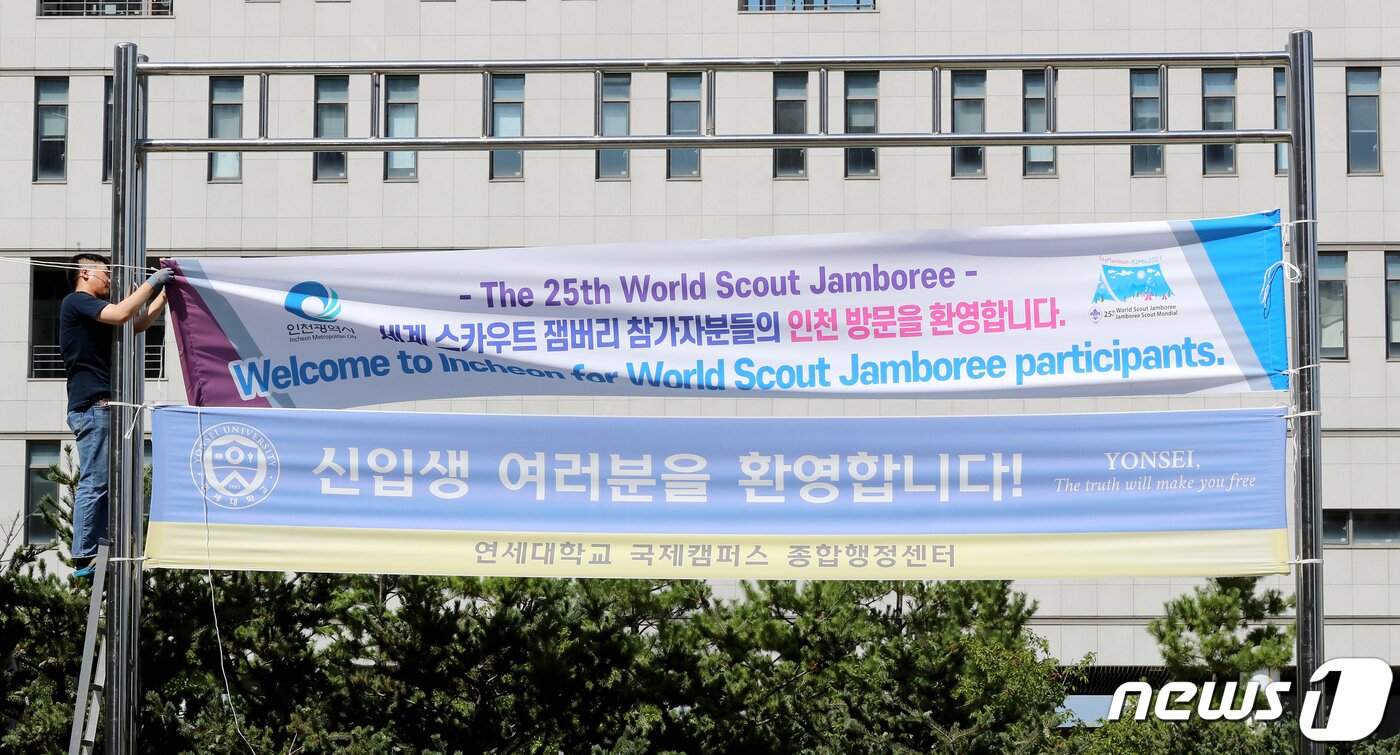 본문 이미지 - 8일 오후 인천 연수구 연세대 국제캠퍼스에서 관계자가 외국 스카우트 대표단 방문을 환영하는 현수막을 설치하고 있다. 정부는 태풍 '카눈'이 북상함에 새만금 국제 잼버리에 참가한 외국 스카우트 대표단을 서울과 경기 등 8개 시·도에 마련한 숙소로 분산 이동 시킨다. 2023.8.8/뉴스1 ⓒ News1 장수영 기자