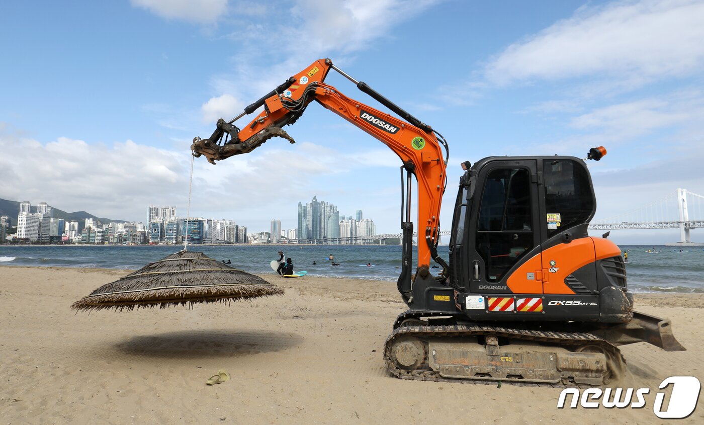 본문 이미지 - 제6호 태풍 '카눈'이 북상 중인 8일 오후 부산 수영구 광안리해수욕장에 설치된 파라솔이 철거되고 있다. 2023.8.8/뉴스1 ⓒ News1 윤일지 기자