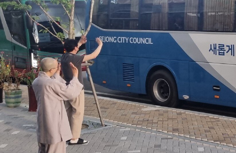 본문 이미지 - 사찰음식 체험을 마치고 떠나는 불가리아 대원들을 배웅하는 동화스님. (세종전통문화체험관 제공) /뉴스1