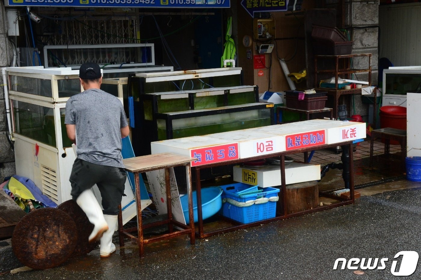 본문 이미지 - 제6호 태풍 '카눈'이 북상 중인 9일 오전 경남 창원시 마산합포구 마산어시장에서 한 상인이 태풍에 대비해 집기류를 가게 내부로 옮기고 있다. 2023.8.9/뉴스1 박민석 기자
