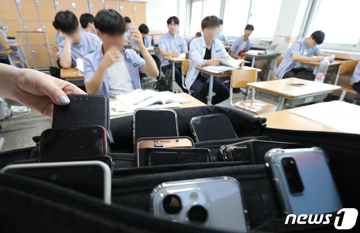 본문 이미지 - 교육부가 교권 확립 및 학생의 학습권 보호를 위한 '교원의 학생생활지도에 관한 고시'와 '유치원 교원의 교육활동 보호를 위한 고시'가 교육 현장에 적용이 시작되면서 수업 중 휴대전화 사용 시 휴대전화를 압수할 수 있게됐다. 1일 대전 중구 동산고등학교 1학년 교실에서 휴대폰을 수거하고 있다. 이 학교는 학생회, 학부모와 협의를 통해 등교시 학생들의 휴대폰을 수거한 뒤 하교시 돌려준다. 2023.9.1/뉴스1 ⓒ News1 김기태 기자