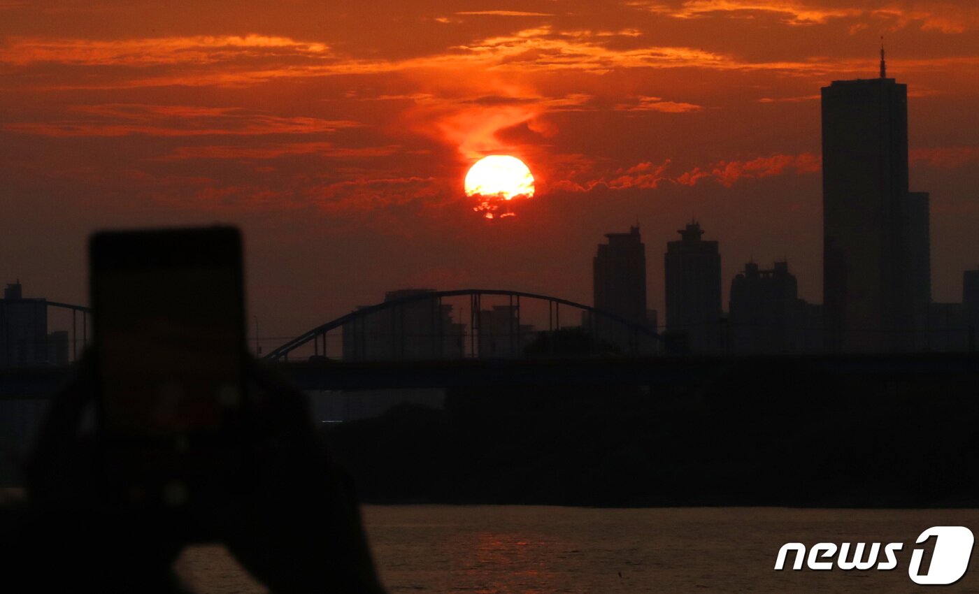 본문 이미지 - 주말인 10일 오후 서울 잠수교에서 열린 ‘차 없는 잠수교 뚜벅뚜벅 축제’를 찾은 한 시민이 휴대폰으로 아름답게 물들어가는 하늘의 노을 사진을 찍고 있다. 2023.09.10./뉴스1 ⓒ News1 박세연 기자