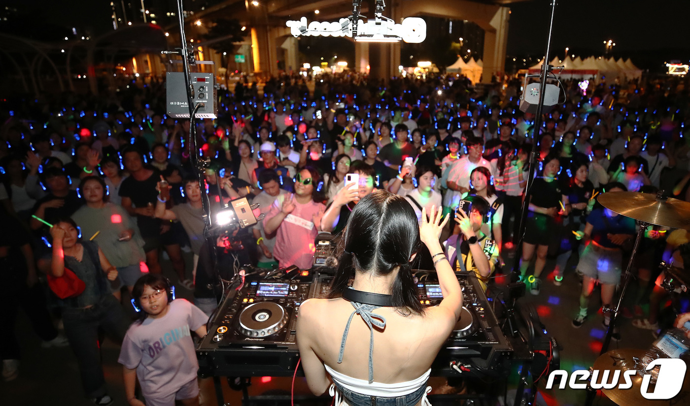 (서울=뉴스1) 박세연 기자 = 주말인 10일 저녁 서울 반포한강공원에서 열린 ‘차 없는 잠수교 뚜벅뚜벅 축제’ 한강 무소음 DJ 파티를 찾은 시민들이 무선 헤드셋으로 음악을 들으 …