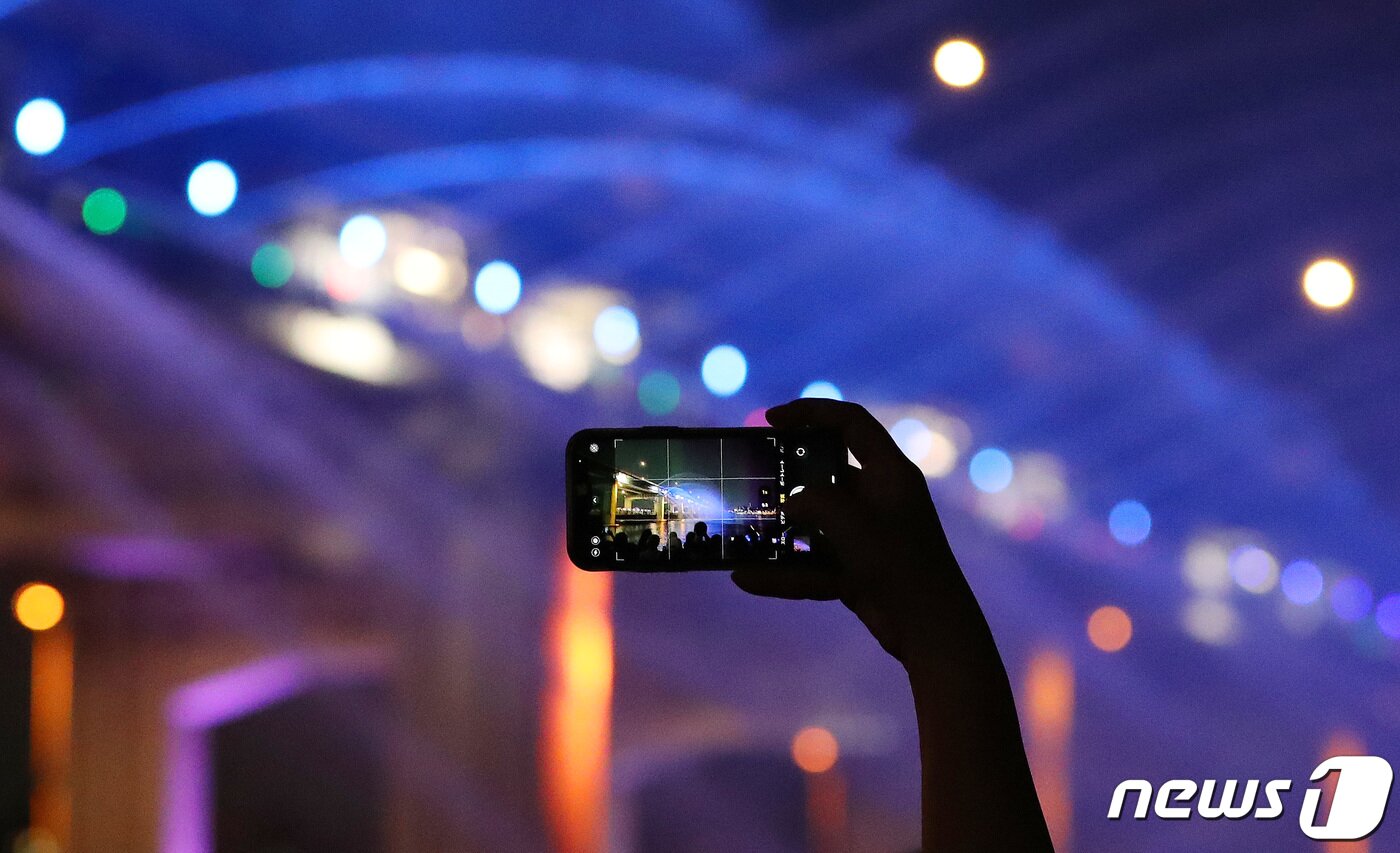 본문 이미지 - 주말인 10일 저녁 서울 반포한강공원을 찾은 한 시민이 휴대폰으로 반포대교 달빛무지개분수 사진을 찍고 있다. 2023.09.10/뉴스1 ⓒ News1 박세연 기자