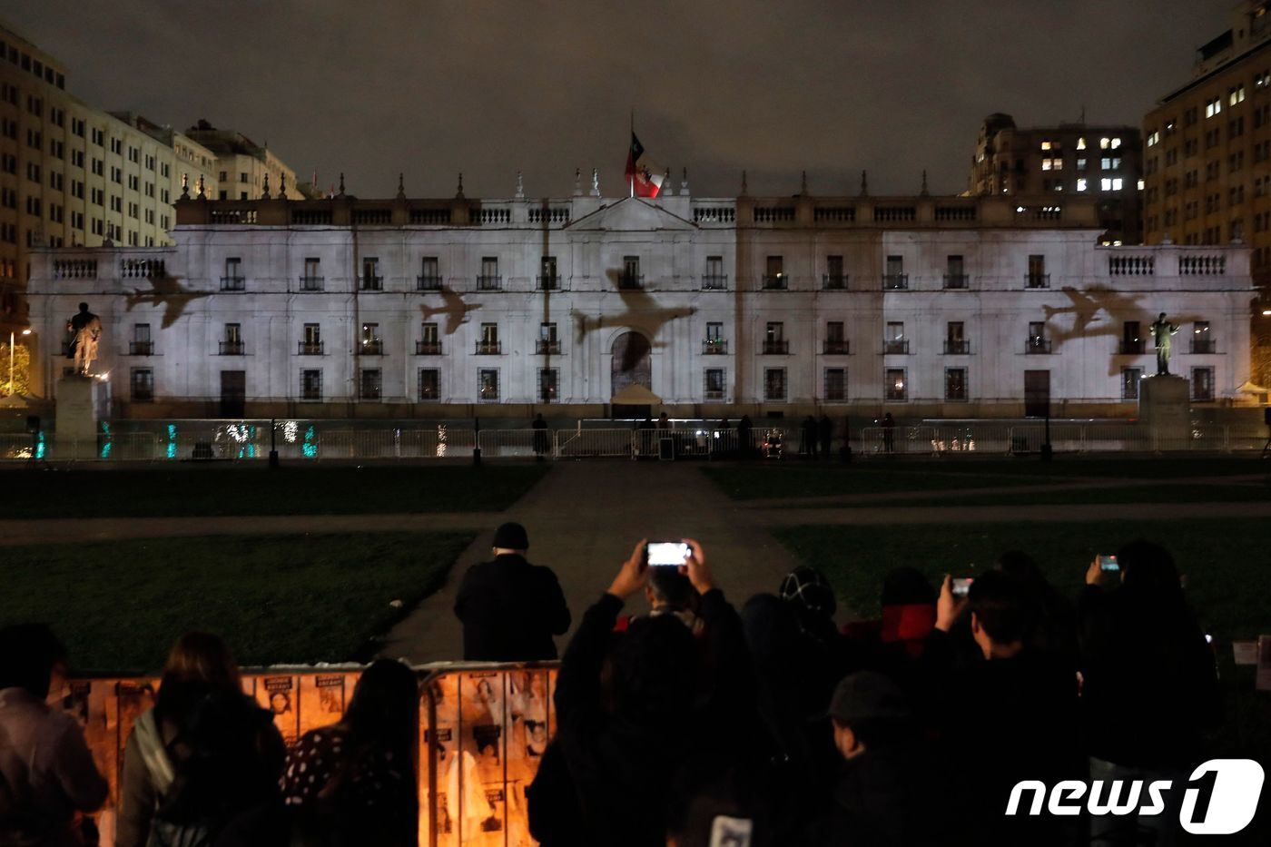 본문 이미지 - 군부 쿠데타 발발 50주년을 맞은 11일(현지시간) 칠레 수도 산티아고의 대통령궁(라 모데나)에 군부가 폭격에 사용한 비행기가 투사된 모습이다. 당시 칠레 육군 총사령관이었던 아우구스토 피노체트는 쿠데타를 일으켜 살바도르 아옌데 대통령을 축출했고 이 과정에서 라 모데나에 폭격을 퍼부었다. 2023.9.11. ⓒ AFP=뉴스1 ⓒ News1 김성식 기자