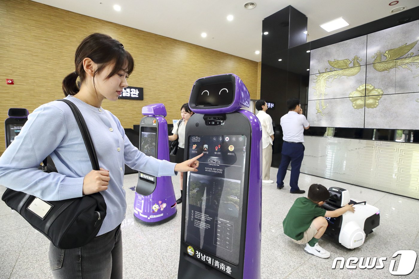 지난해 9월 청남대 대통령기념관에서 관람객들이 안내로봇에게 관람 정보를 안내받고 있다. &#40;KT 제공&#41; 2023.9.13/뉴스1