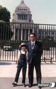 본문 이미지 - 아버지 오부치 게이조 전 총리와 일본 국회의사당 앞에서 기념 사진을 찍는 딸 유코. 1980년. (출처 : 오부치 유코 누리집)