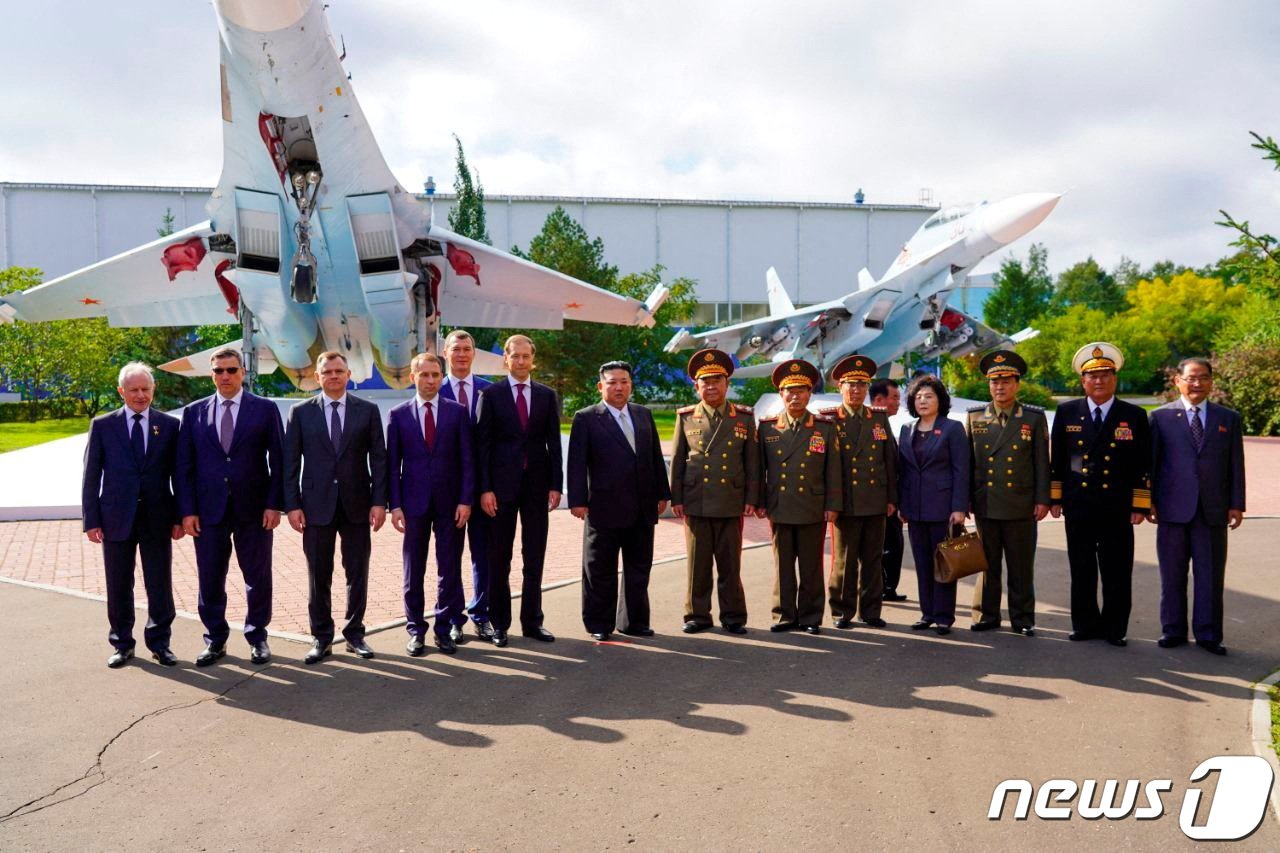 본문 이미지 - 15일(현지시간) 러시아 하바롭스크주(州) 콤소몰스크나아무에 있는 항공기 공장에서 김정은 북한 노동당 총비서와 러시아 부총리가 이끄는 대표단이 전투기 앞에서 기념 사진을 촬영하고 있다. 2023.09.15/ ⓒ 로이터=뉴스1 ⓒ News1 홍유진 기자