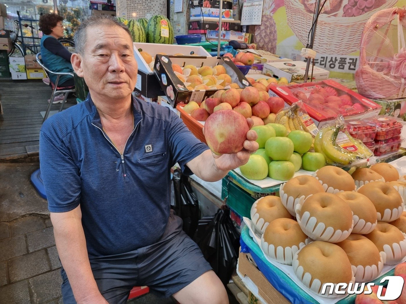 추석 명절을 아흐레 19일 경기 구리시 구리전통시장에서  과일장수 박석규씨&#40;70&#41;가 가판대에 진열돼 있는 사과를 들고 있다.박씨는 사괏값이 평년 대비 두 배 이상 급등하면서 팔리지 않는다고 토로했다.2023.09.19./뉴스1 양희문 기자