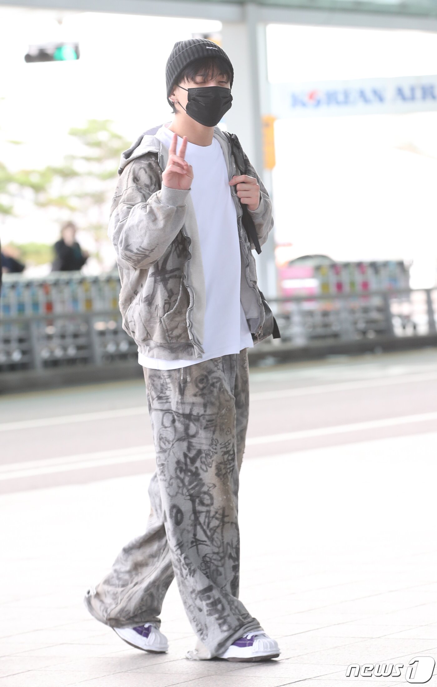 본문 이미지 - 방탄소년단(BTS) 정국이 해외 일정을 위해 21일 인천국제공항에 도착해 미국 뉴욕으로 출국하며 브으를 그리고 있다. ⓒ News1 권현진 기자