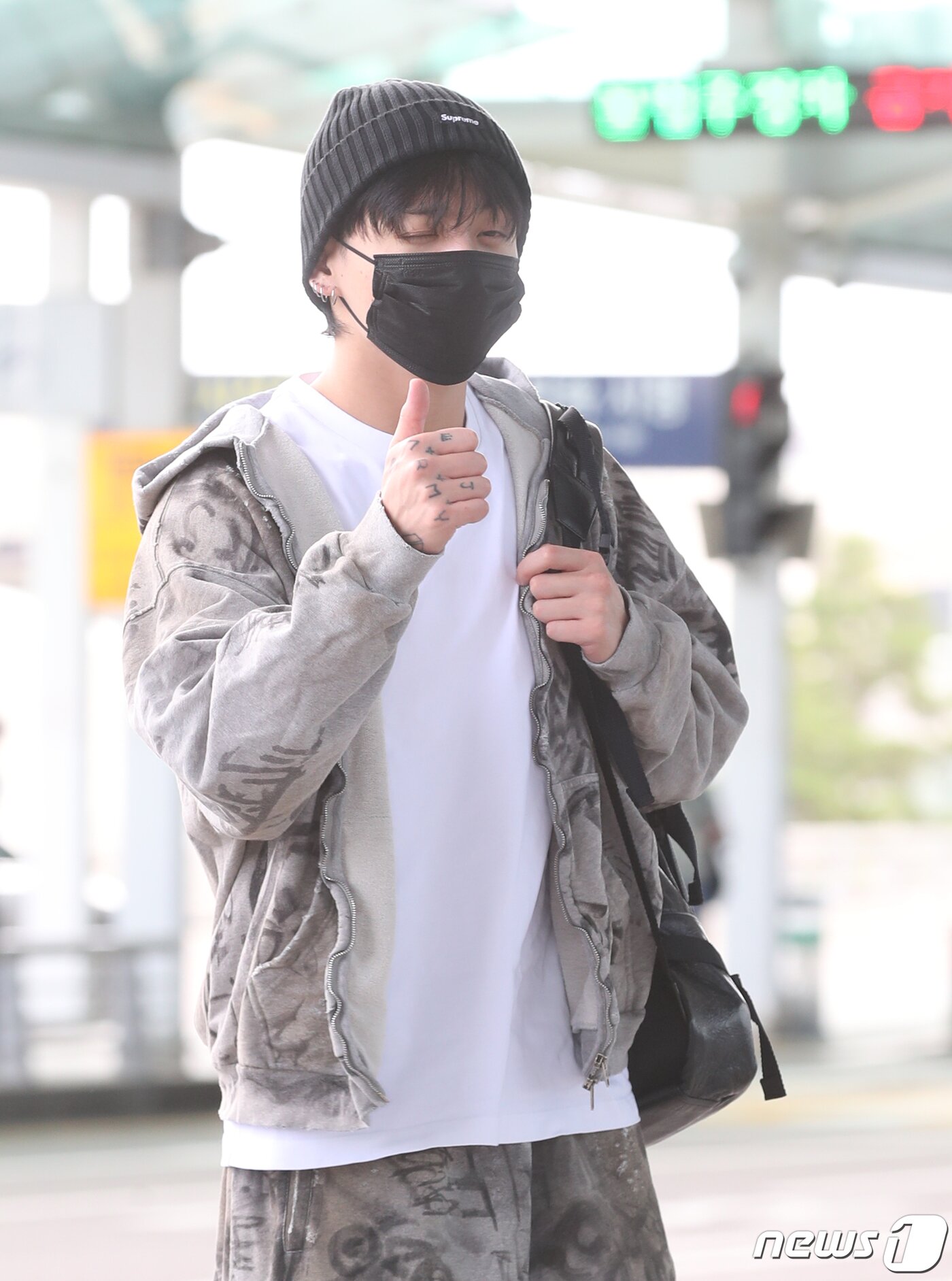본문 이미지 - 방탄소년단(BTS) 정국이 해외 일정을 위해 21일 인천국제공항에 도착해 미국 뉴욕으로 출국하며 엄지를 치켜들고 있다. ⓒ News1 권현진 기자