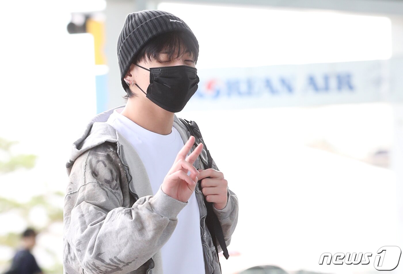 본문 이미지 - 방탄소년단(BTS) 정국이 해외 일정을 위해 21일 인천국제공항에 도착해 미국 뉴욕으로 출국하며 브이를 그리고 있다. ⓒ News1 권현진 기자