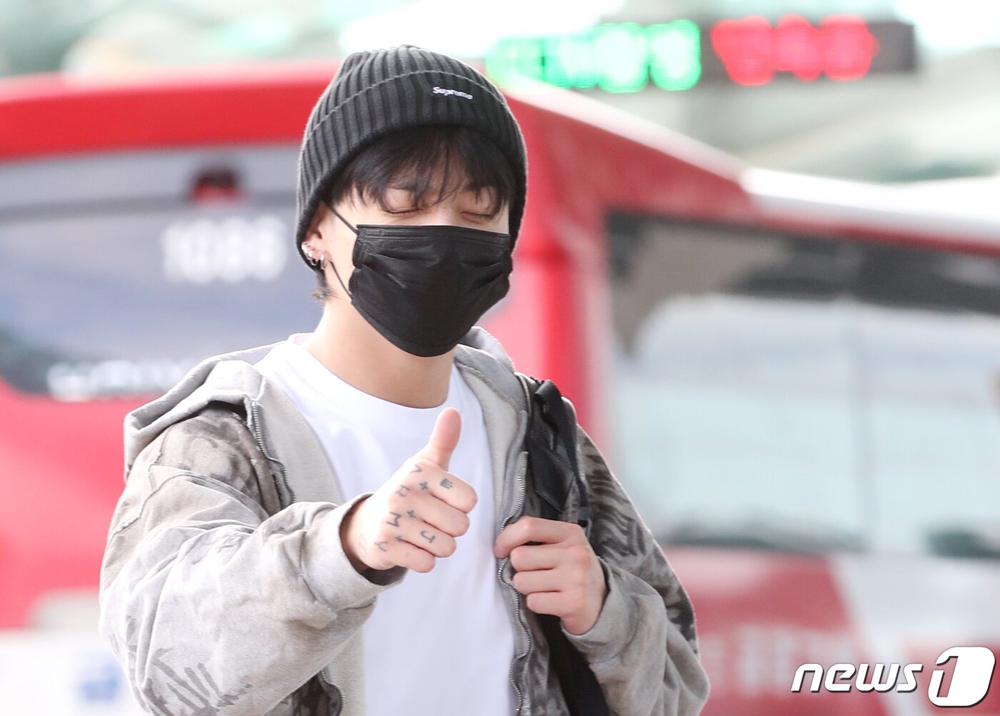 본문 이미지 - 방탄소년단(BTS) 정국이 해외 일정을 위해 21일 인천국제공항에 도착해 미국 뉴욕으로 출국하며 엄지를 치켜들고 있다. ⓒ News1 권현진 기자
