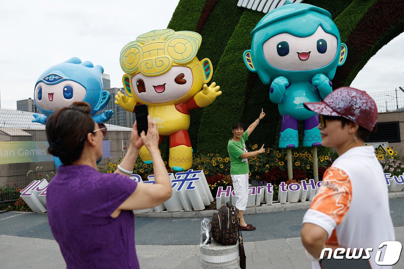 본문 이미지 - 시민들이 항저우 아시안 게임의 마스코트를 배경으로 기념촬영을 하고 있다. ⓒ 로이터=뉴스1 ⓒ News1 박형기 기자