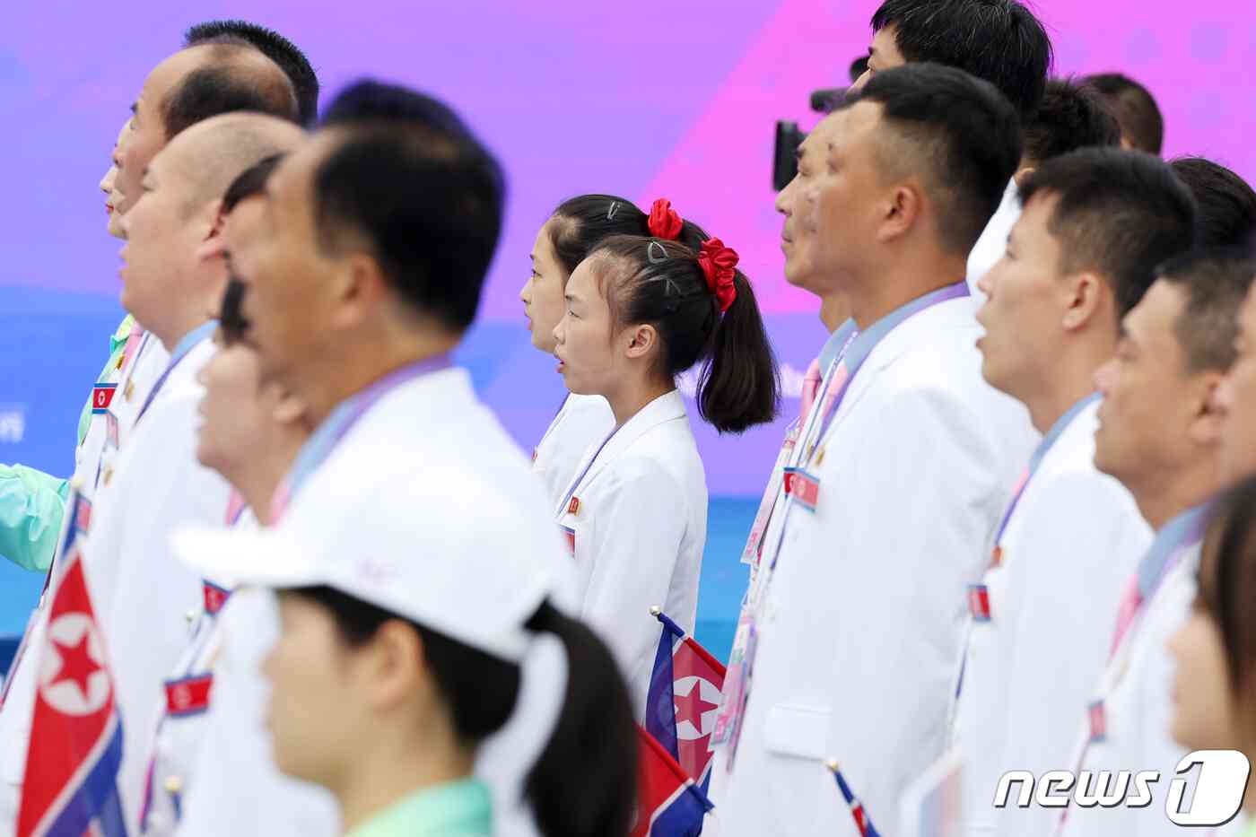 2022 항저우 아시안게임 개막을 하루 앞둔 22일 오전 중국 항저우 아시안게임 선수촌 국기광장에서 열린 입촌식에서 북한 선수단이 인공기가 게양되는 모습을 지켜보며 국가를 제창하고 있다. 2023.9.22/뉴스1 © News1 민경석 기자
