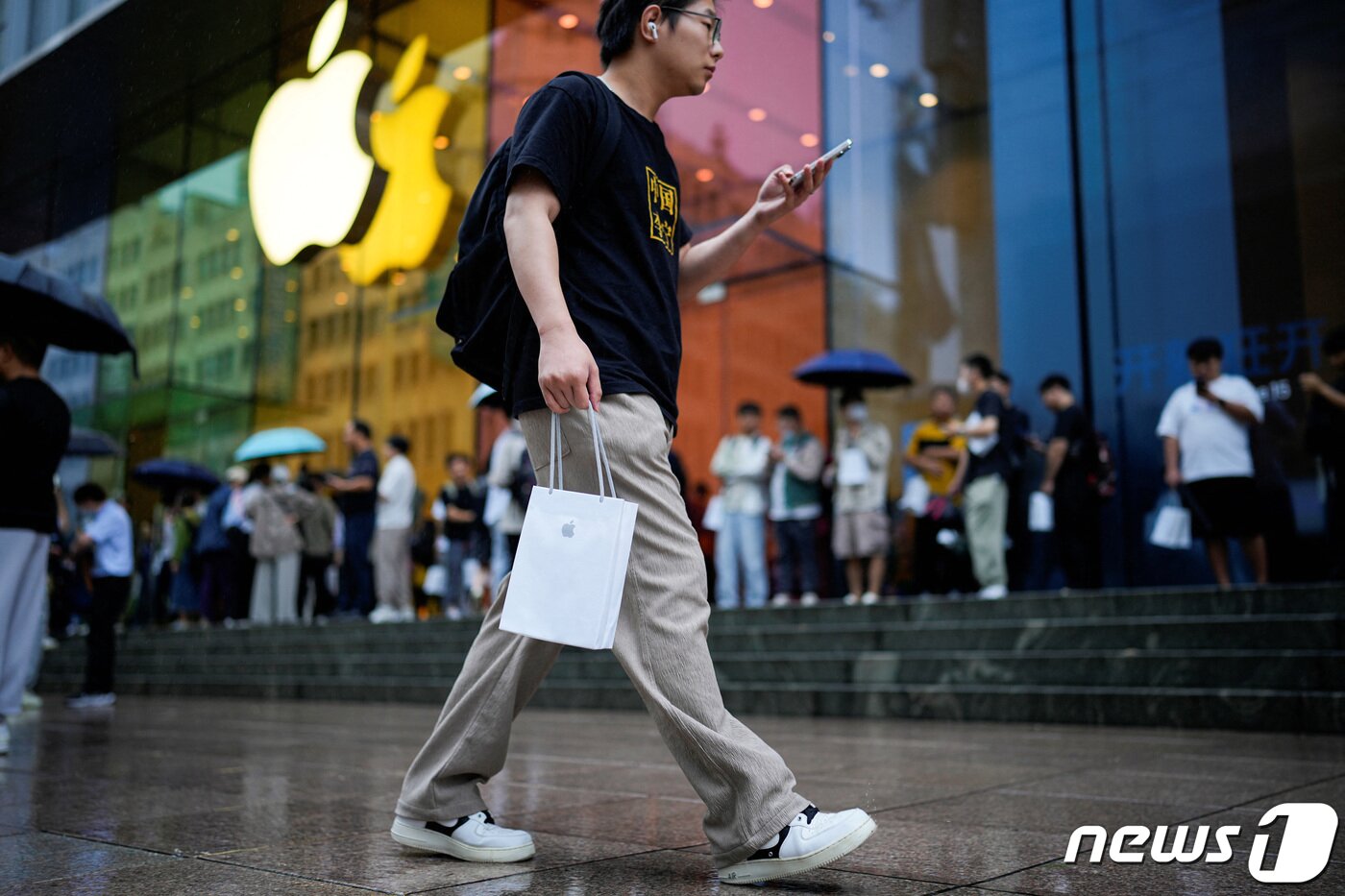 본문 이미지 - 한 남성이 아이폰을 구매한 뒤 집으로 향하고 있다. 2023.09.22/ ⓒ 로이터=뉴스1 ⓒ News1 장성희 기자