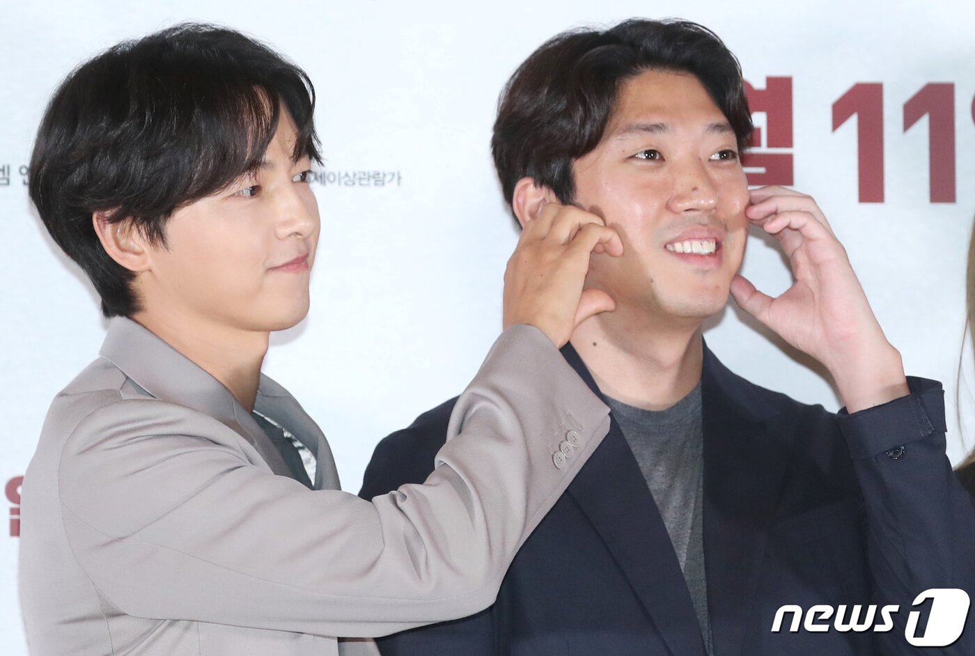 본문 이미지 - 배우 송중기(왼쪽)가 22일 서울 강남구 메가박스 코엑스에서 열린 영화 '화란‘ 언론시사회에서 김창훈 감독의 볼에 하트를 그리고 있다. ⓒ News1 권현진 기자