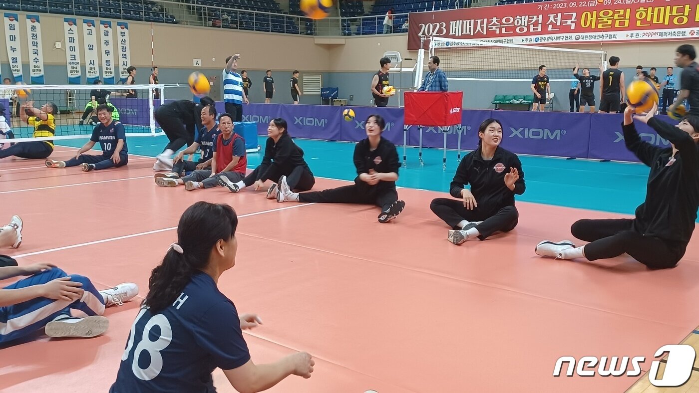 본문 이미지 - 23일 광주 빛고을체육관에서 열린 2023 페퍼저축은행컵 전국 어울림 한마당 배구대회에서 여자프로배구 AI페퍼스 선수들이 장애인 좌식배구 참가 선수들과 연습경기를 갖고 있다.2023.9.23/뉴스1 ⓒ News1