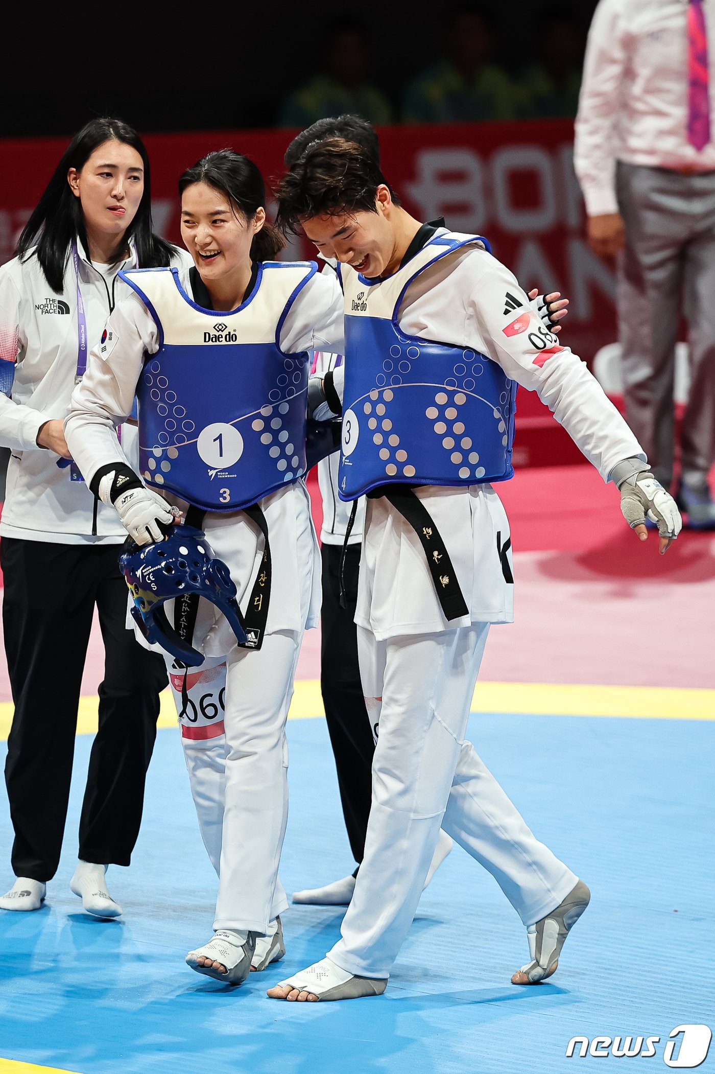 본문 이미지 - 김잔디(왼쪽), 박우혁이 25일 중국 항저우 린안 스포츠문화·전시센터에서 열린 2022 항저우 아시안게임 태권도 겨루기 혼성 단체전 4강 우즈베키스탄과의 경기에서 승리한 후 서로를 격려하고 있다. ⓒ News1 유승관 기자