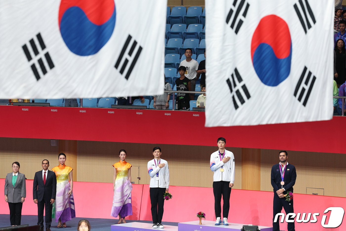 오상욱과 구본길이 25일 오후 중국 항저우 디안즈대학 체육관에서 열린 2022 항저우 아시안게임 펜싱 남자 사브르 개인전 메달 수여식에서 국기에 대한 경례를 하고 있다. 이번 대회에서 오상욱과 구본길은 각각 금메달과 은메달을 차지했다. 2023.9.25/뉴스1 ⓒ News1 신웅수 기자