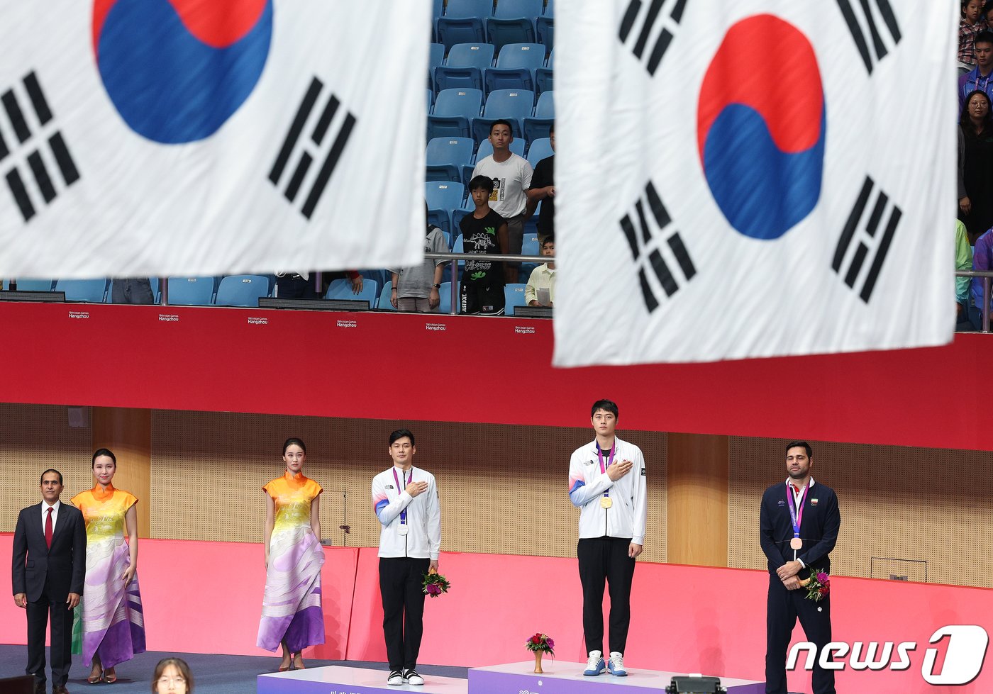 오상욱과 구본길이 25일 오후 중국 항저우 디안즈대학 체육관에서 열린 2022 항저우 아시안게임 펜싱 남자 사브르 개인전 메달 수여식에서 국기에 대한 경레를 하고 있다. 이번 대회에서 오상욱과 구본길은 각각 금메달과 은메달을 차지했다. 2023.9.25/뉴스1 ⓒ News1 신웅수 기자