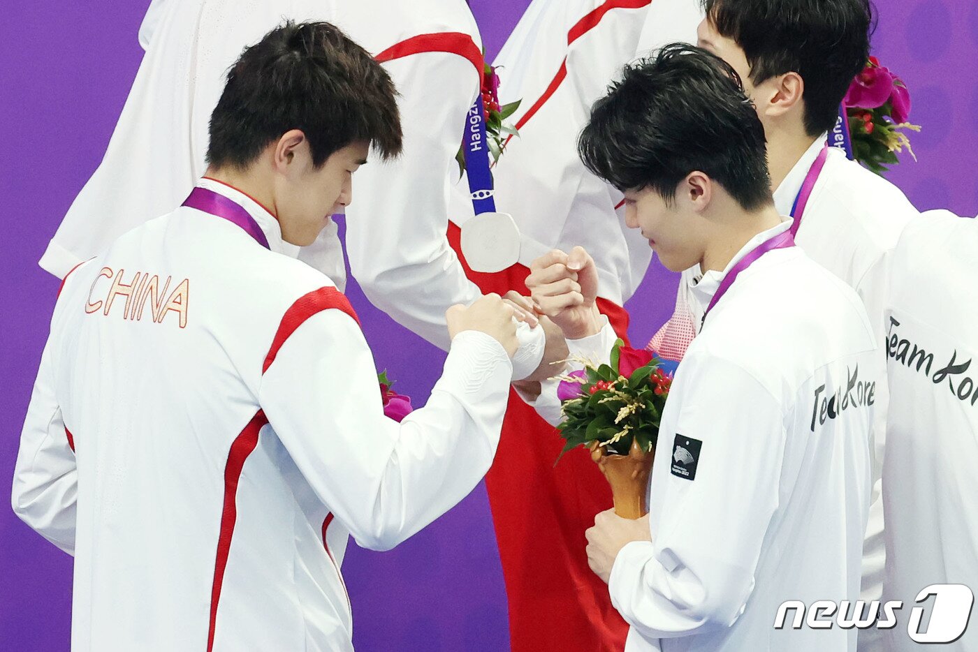 본문 이미지 - 25일 오후 중국 항저우 올림픽 스포츠센터 수영장에서 열린 남자 계영 800m 결승전이 끝난 뒤 대한민국 황선우가 중국의 판잔와 주먹 인사를 나누고 있다. 2023.9.25/뉴스1 ⓒ News1 민경석 기자