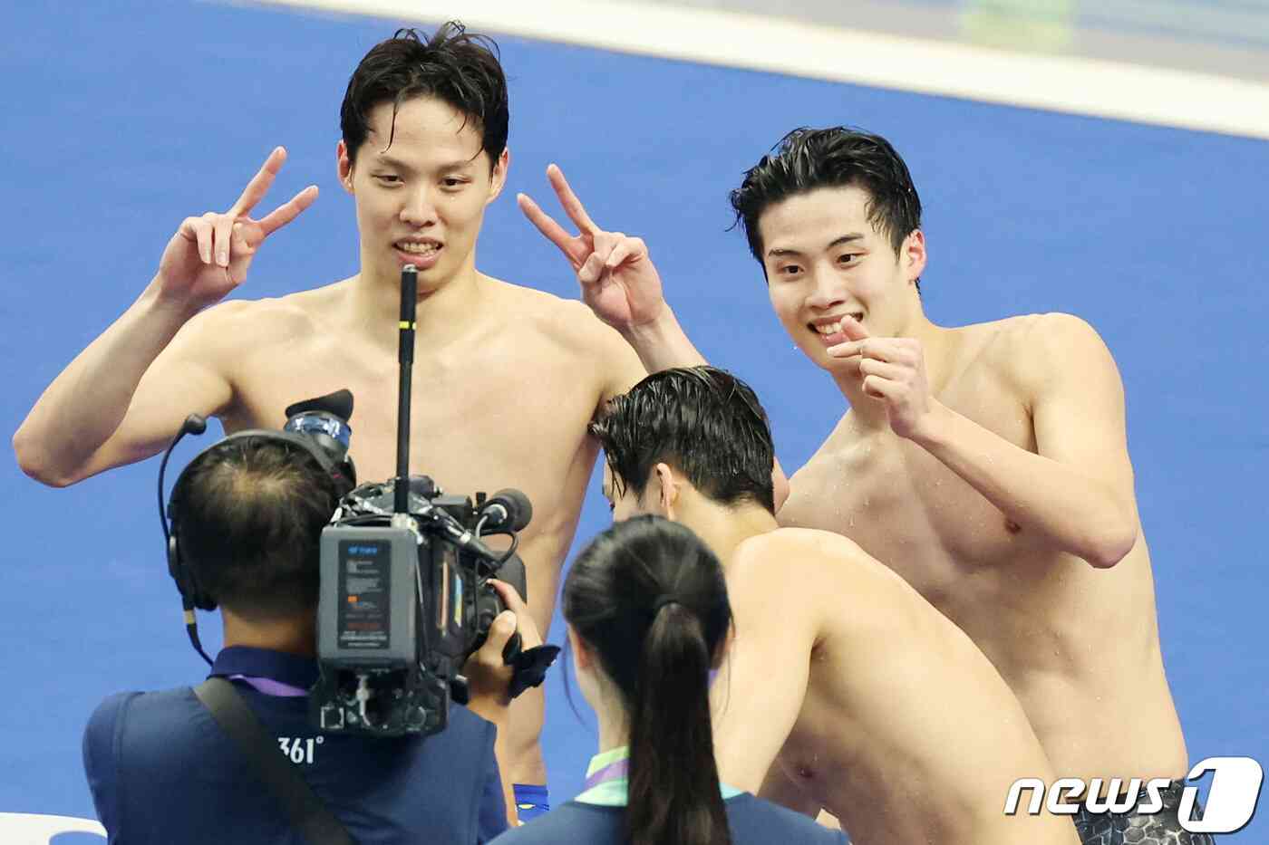25일 오후 중국 항저우 올림픽 스포츠센터 수영장에서 열린 남자 계영 800ｍ 결승전에서 대한민국 황선우(오른쪽)와 양재훈이 금메달을 확정 지은 뒤 중계 카메라에 포즈를 취하고 있다. 2023.9.25/뉴스1 © News1 민경석 기자