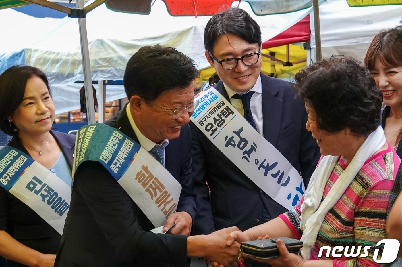 본문 이미지 - 이선호 더불어민주당 울산시당위원장이 울산 울주군 남창옹기종기시장에서 상인들과 인사를 나누고 있다. (민주당 울산시당 제공) 