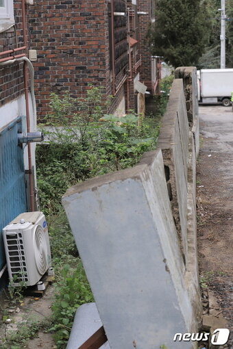 본문 이미지 -  1980년대에 준공된 약산마을 빌라들은 노후도고 높아 주민 안전을 위협하고 있다. 한 빌라의 담벽이 무너질 듯 위태로운 모습. /박대준 기자 