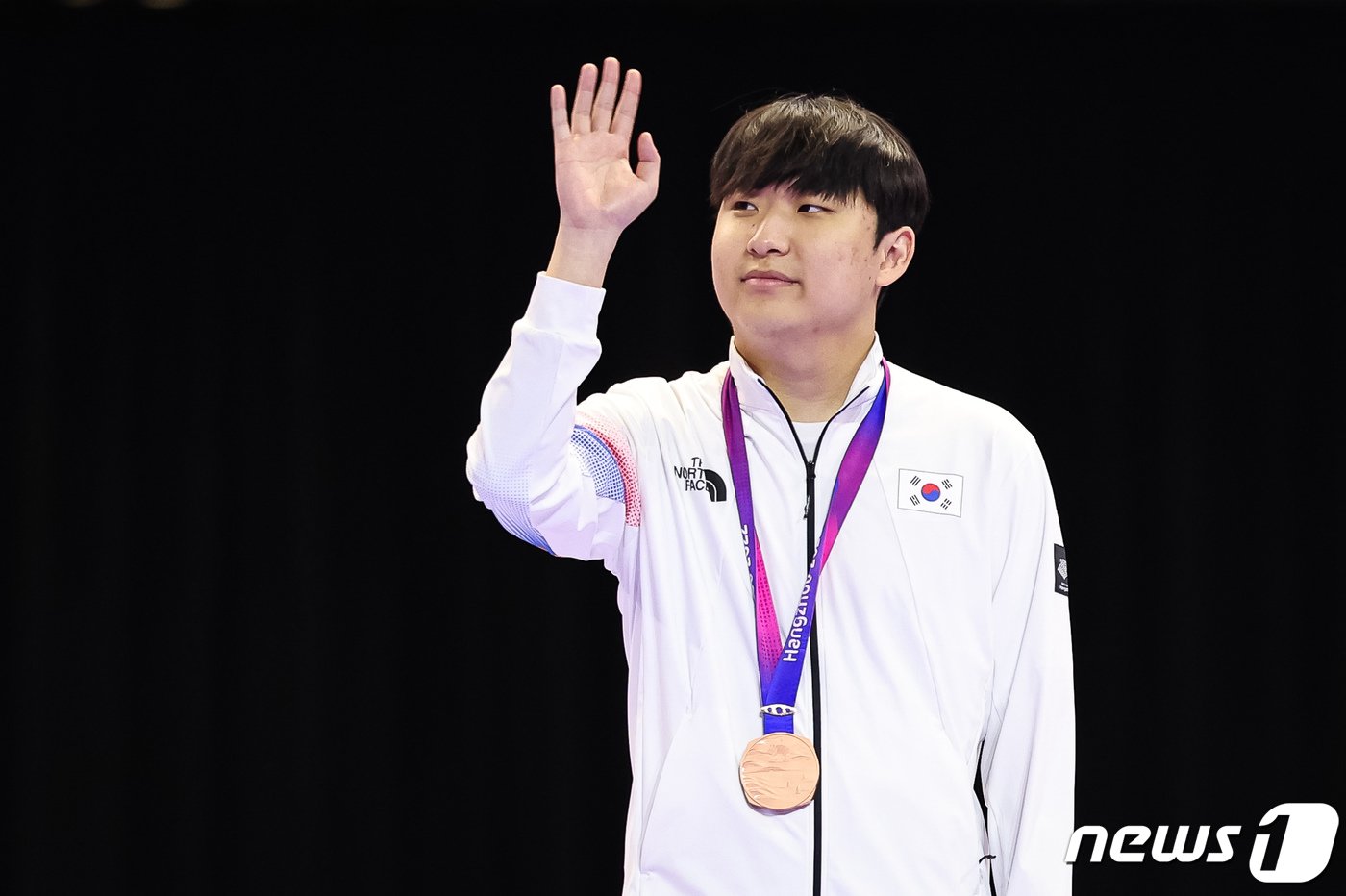 본문 이미지 - 곽준혁이 27일 중국 항저우 베이징위안 생태공원 내 e스포츠 주경기장에서 열린 2022 항저우 아시안게임 'FC온라인' 시상식에서 동메달을 목에 걸고 관중들을 향해 인사하고 있다. 2023.9.27/뉴스1 ⓒ News1 유승관 기자