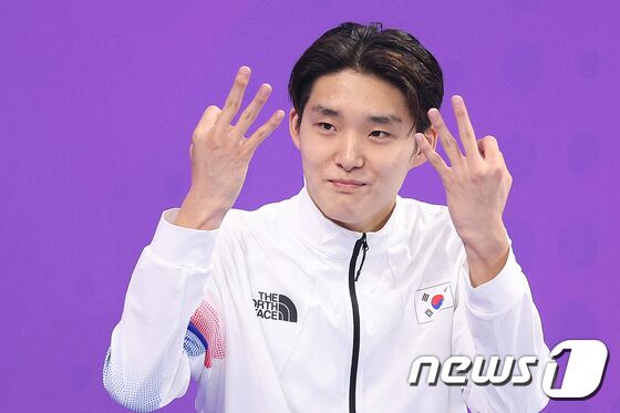 김우민이 29일 중국 항저우 올림픽 스포츠센터 아쿠아틱스포츠 아레나에서 열린 2022 항저우 아시안게임 남자 자유형 400m 시상식에서 시상대에 오르며 3관왕을 의미하는 손가락 세 개를 들어보이고 있다. 2023.9.29/뉴스1 © News1 신웅수 기자