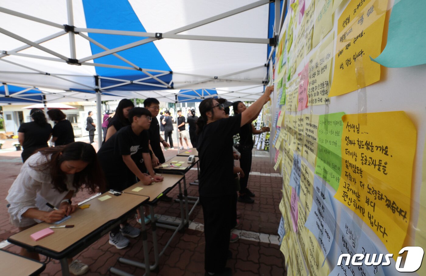 본문 이미지 - 3일 서울 양천구의 한 초등학교에 마련된 교사 A씨의 추모공간을 찾은 시민들이 고인을 추모하고 있다. 올해로 14년차 교사인 A씨는 지난달 31일 경기 고양시의 한 아파트에서 극단적 선택으로 숨졌다. 2023.9.3/뉴스1 ⓒ News1 신웅수 기자