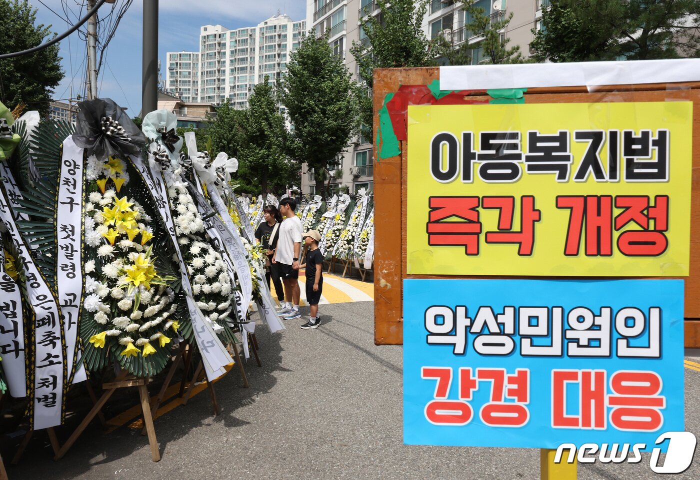 본문 이미지 - 3일 서울 양천구의 한 초등학교에 마련된 교사 A씨의 추모공간을 찾은 추모객들이 근조 화환을 보고 있다. 올해로 14년차 교사인 A씨는 지난달 31일 경기 고양시의 한 아파트에서 극단적 선택으로 숨졌다. 2023.9.3/뉴스1 ⓒ News1 신웅수 기자