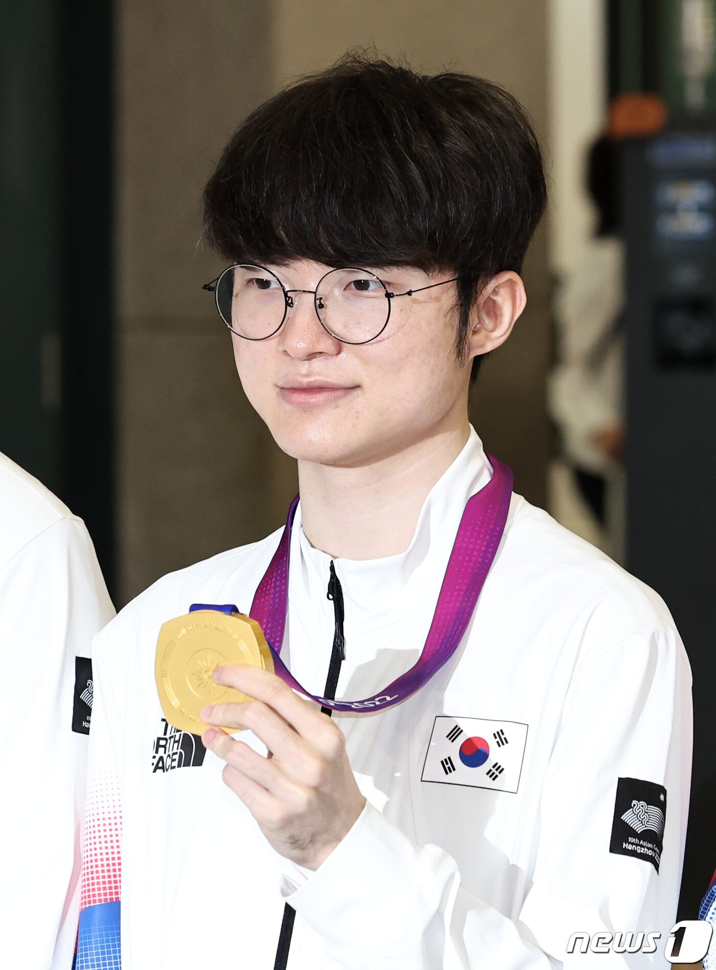 본문 이미지 - '2022 항저우 아시안게임' e스포츠 리그 오브 레전드(LoL)에서 금메달을 획득한 페이커 이상혁이 30일 인천국제공항 제1여객터미널을 통해 귀국해 메달을 들어보이고 있다. 2023.9.30 ⓒ 뉴스1 구윤성 기자