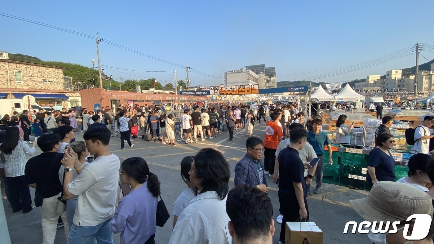 본문 이미지 - 예산시장에서 개최된 ‘2023 예산맥주페스티벌’에서 방문객들이 맥주와 바베큐&#40;아사도&#41;를 맛보기 위해 줄을 서 있다.&#40;예산군 제공&#41;/뉴스1