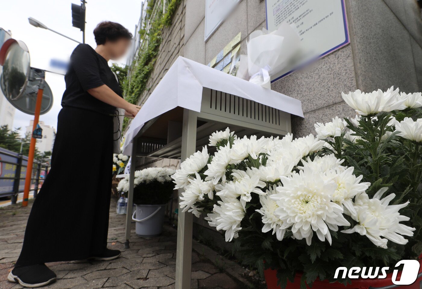 본문 이미지 - 4일 오후 경기 용인시의 한 고등학교 앞에 마련된 체육교사 A씨의 추모공간을 찾은 시민들이 고인을 추모하고 있다. 지난 3일 체육교사 A씨가 학부모로부터 피소된 뒤 극단선택으로 숨진 채 발견돼 경찰이 본격적인 수사에 나섰다. 2023.9.4/뉴스1 ⓒ News1 김영운 기자