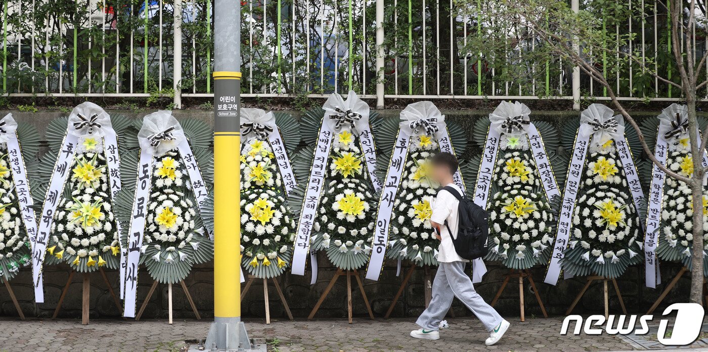 본문 이미지 - 4일 오후 경기 용인시의 한 고등학교 앞에 학부모로부터 피소된 뒤 극단선택으로 숨진 60대 체육교사를 추모하는 근조화환이 놓여 있다. 2023.9.4/뉴스1 ⓒ News1 김영운 기자