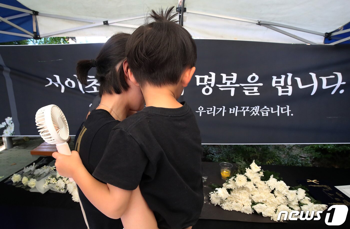 본문 이미지 - 4일 오후 대구시교육청 앞 분수광장에서 열린 서울서이초 사망 교사 49재 추모집회에서 아이를 품에 안은 시민이 분향과 헌화를 하고 있다. 2023.9.4/뉴스1 ⓒ News1 공정식 기자