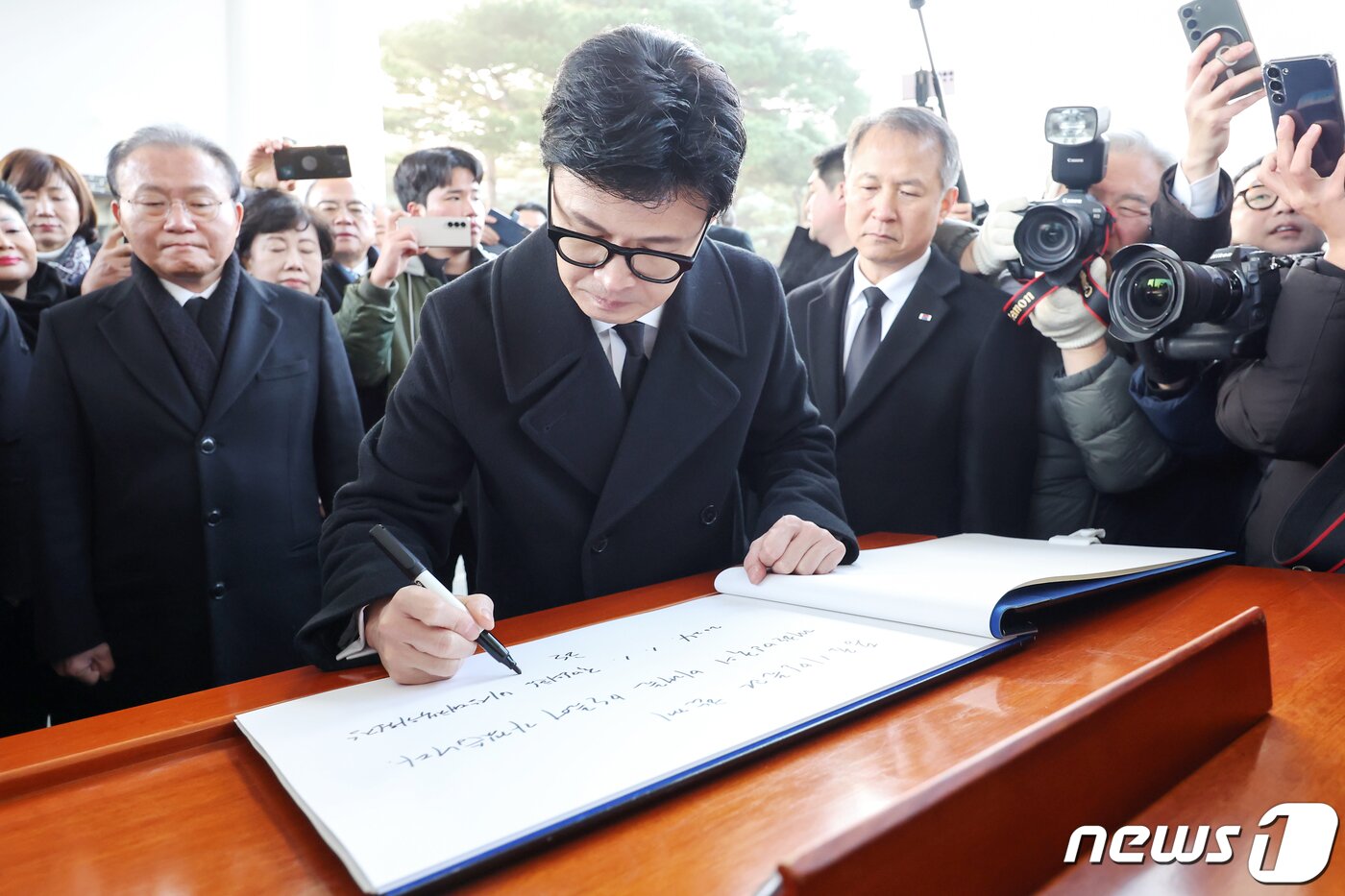 본문 이미지 - 한동훈 국민의힘 비상대책위원장이 1일 오전 서울 동작구 국립서울현충원을 찾아 참배를 마친 뒤 방명록을 작성하고 있다. 2024.1.1/뉴스1 ⓒ News1 민경석 기자