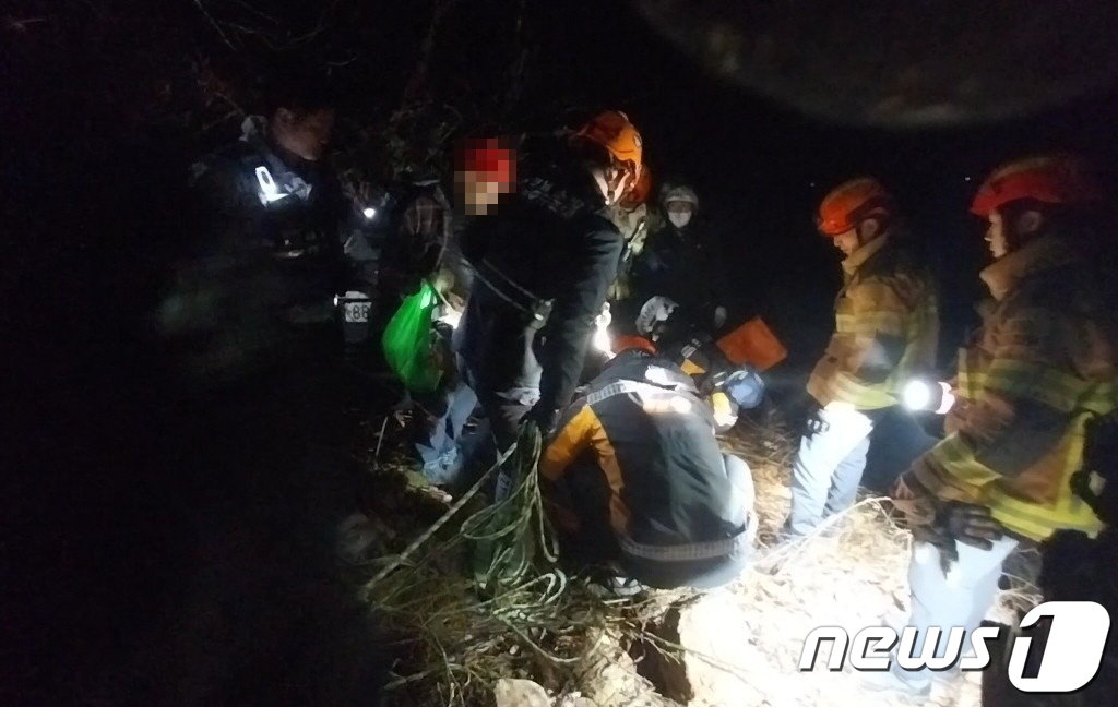 본문 이미지 - 10일 오전 하동군 금남면에서 내리막길을 주행하던 SUV 차량이 빗길에 미끄러져 10m 아래 하천으로 추락해 119구급대원들이 운전자를 구조하고 있다.(경남소방본부 제공)